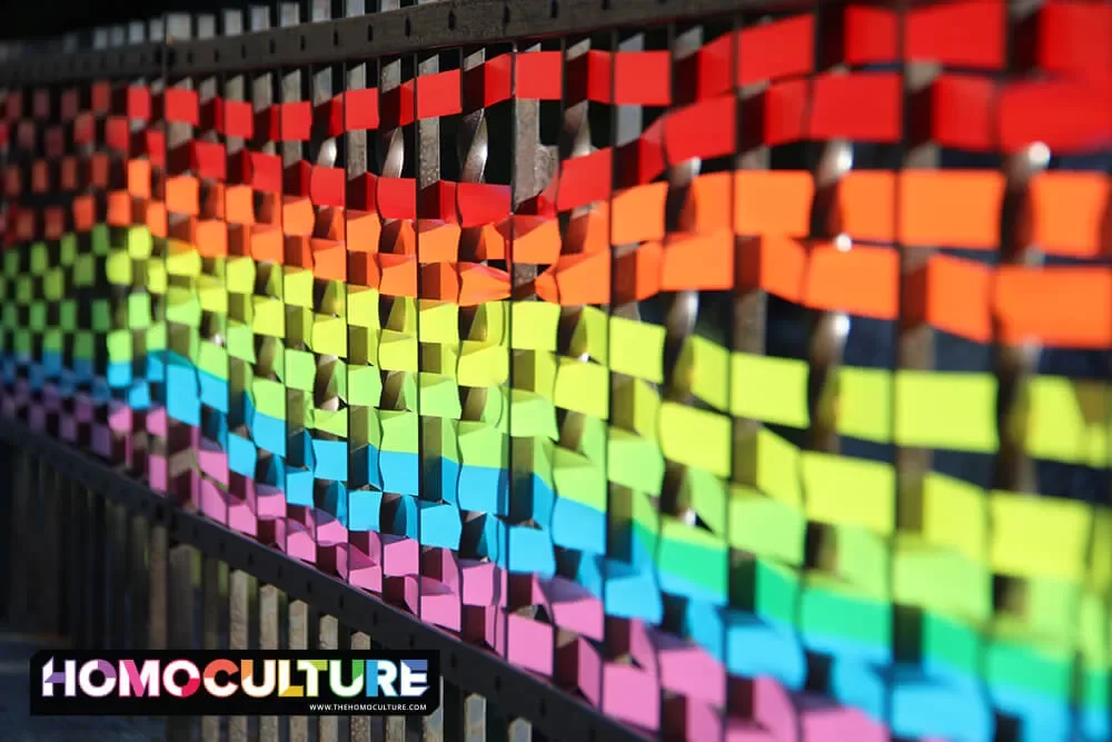 Ribbon woven through a fence to make a rainbow, along Banff Avenue in Banff, Alberta, during Banff Pride 2022. 