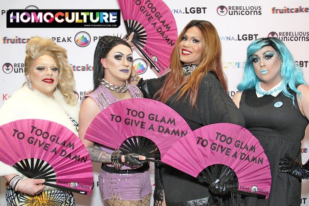 Drag queens posing with circuit party fans.