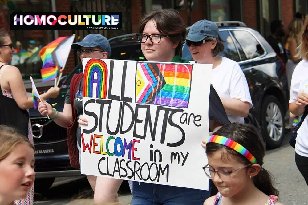 A teacher holding a sign in the 2023 Fredericton Pride parade. 