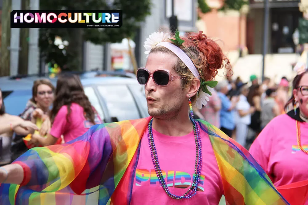 A person wearing a colorful outfit marching in the 2023 Fredericton Pride parade. 