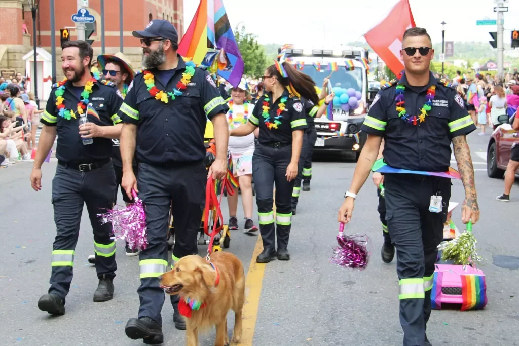 Paramedics march with a dog in the 2023 Fredericton Pride parade. 