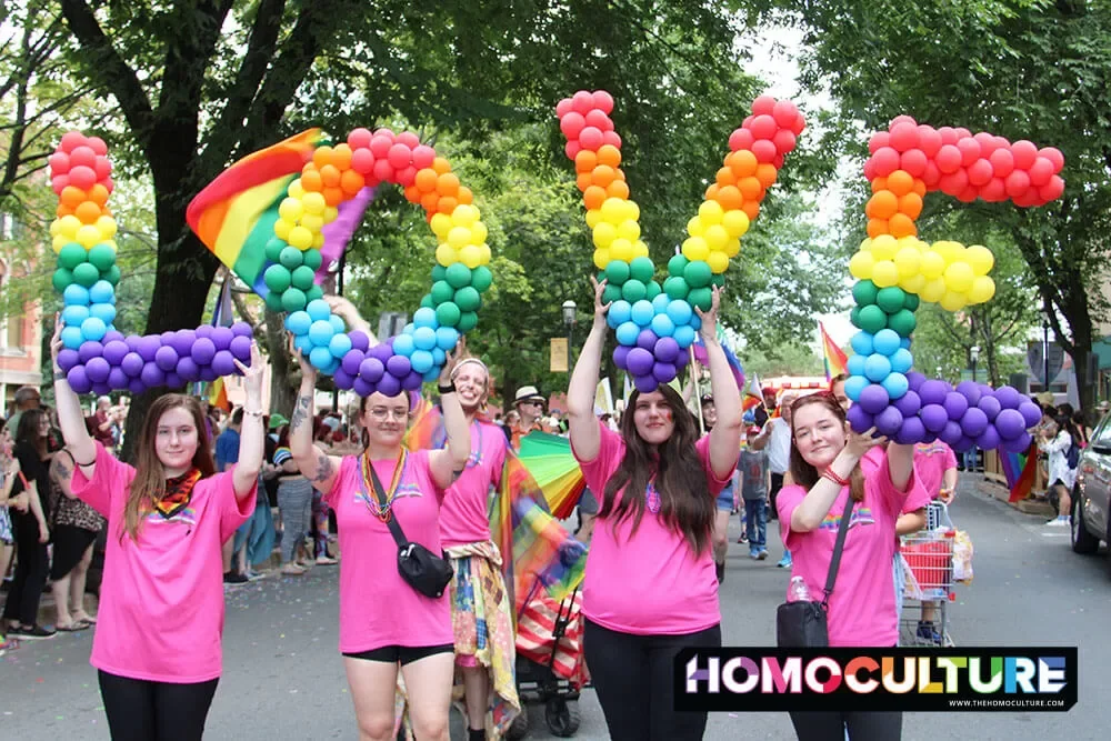 A group of people holding up the word 'LOVE' made from rainbow coloured balloons at the 2023 Fredericton Pride Parade.