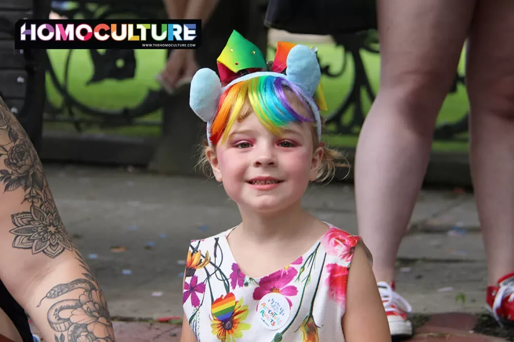 A child wearing Pride accessories while watching the 2023 Fredericton Pride parade. 