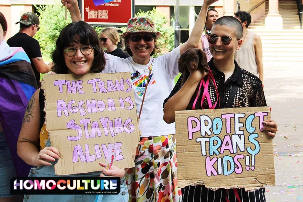 People holding signs supporting transgender rights at the 2023 Fredericton Pride parade. 