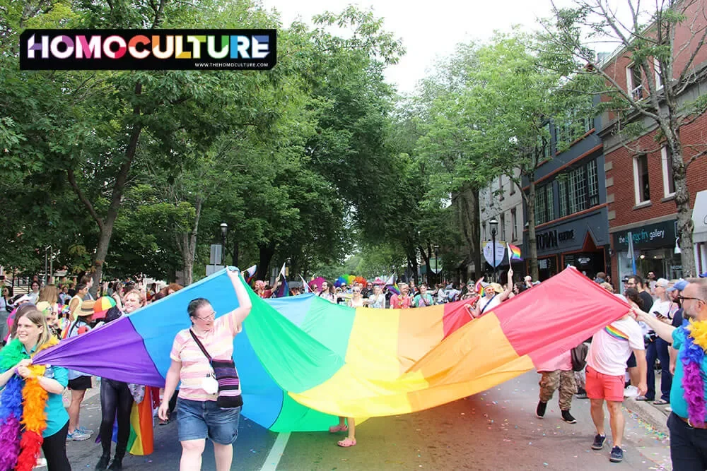 A large Pride flag is carried in the 2023 Fredericton Pride Parade. 