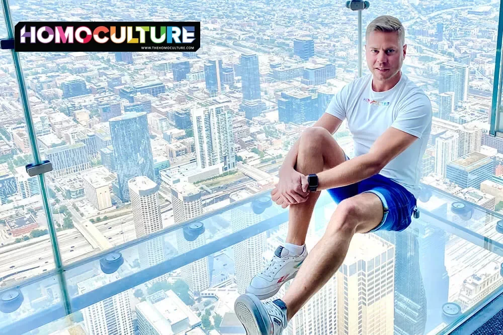 A gay man sitting on the SkyDeck at the top of the Willis Tower in Chicago, Illinois.