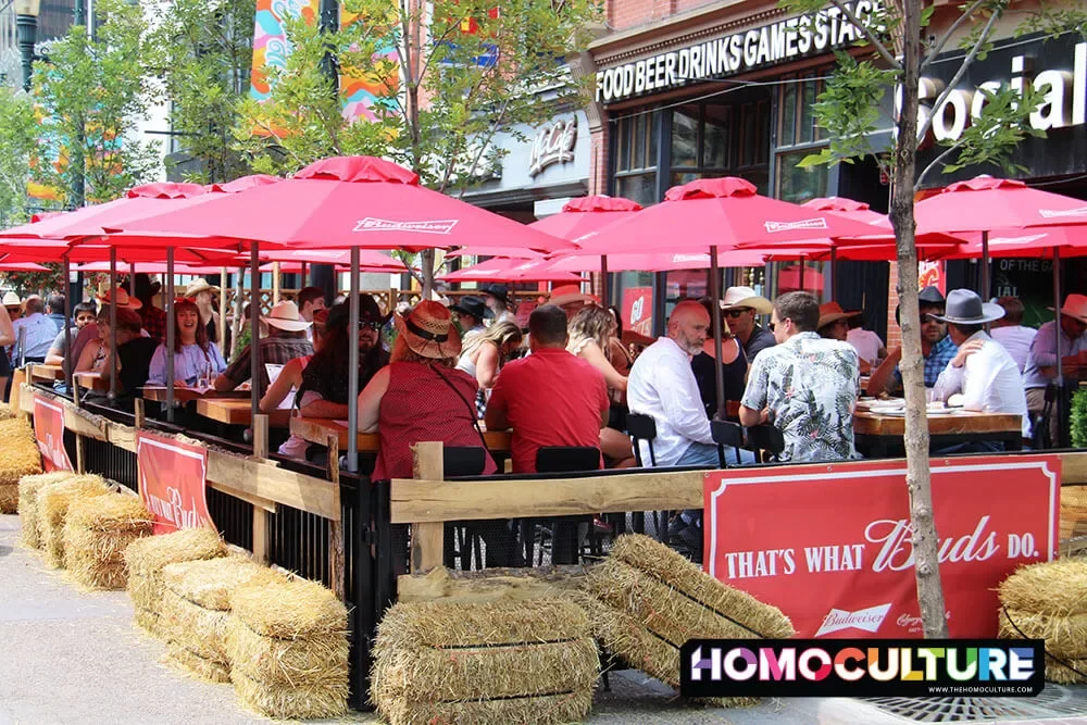 People sitting outside at a patio in downtown Calgary during Calgary Stampede. 