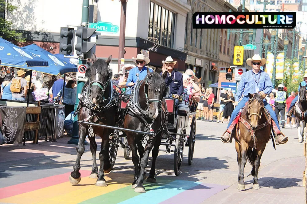 A horse and buggy riding across the Pride crosswalk in downtown Calgary, Alberta, during the 2023 Calgary Stampede.