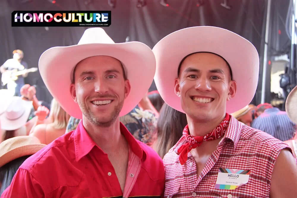 Two gay men wearing traditional white cowboy hats at the 2023 Calgary Stampede.
