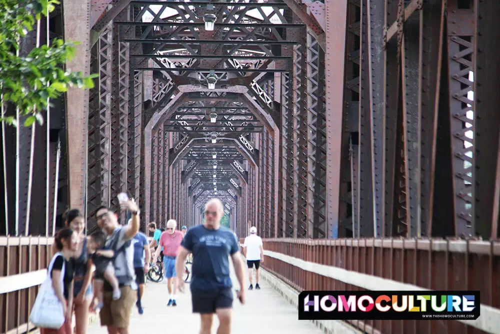 People on a steel bridge crossing the Wolastoq River in Fredericton, New Brunswick. 