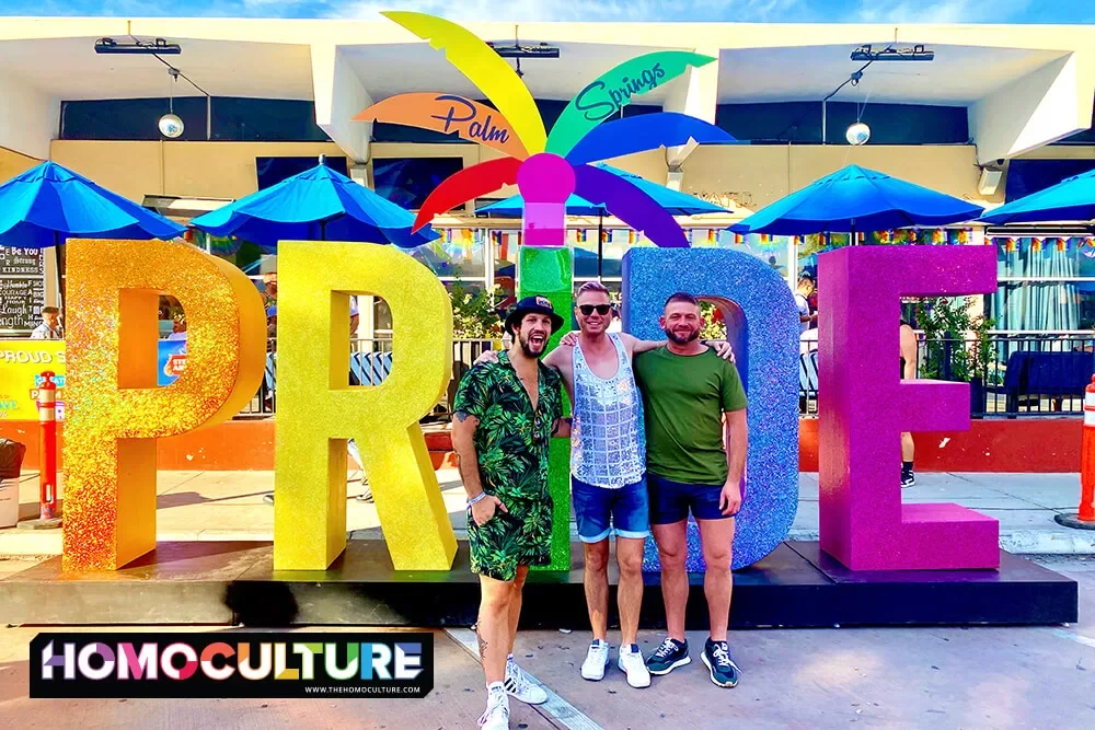 A group of friends pose for a photo in front of a giant Pride sign in the Arenas District during Palm Springs Pride 2022. 