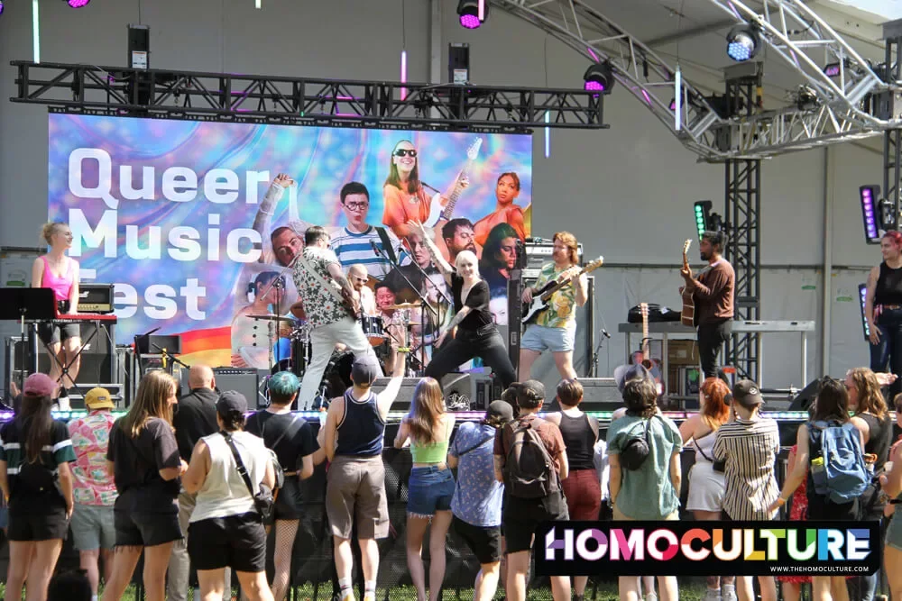 A band performs on stage for a crowd at the 2022 Queer Music Fest. 