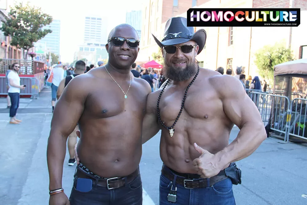 Two muscle-clad men posing for a photo at Folsom Street Fair 2022 in San Francisco. 