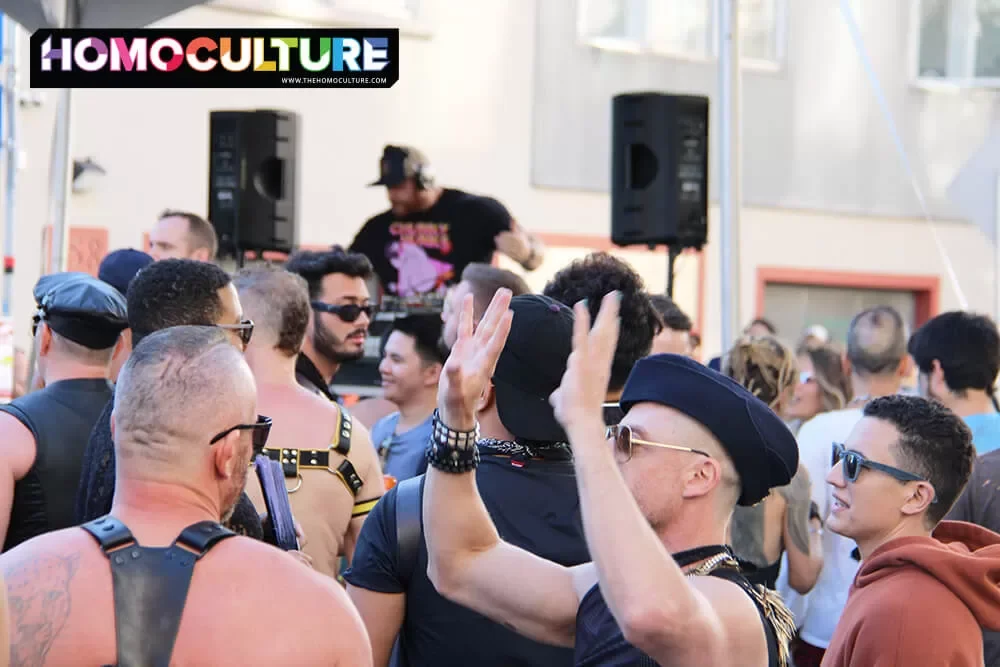A DJ spinning music as a crowd dances at Folsom Street Fair 2022. 
