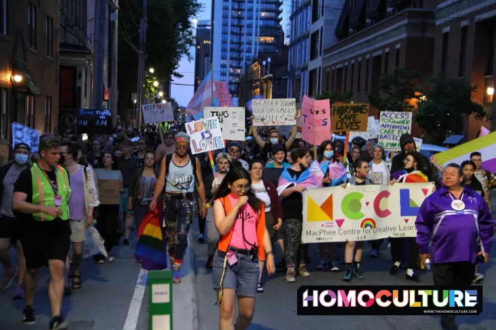 A large group holding signs marching in downtown Halifax during the Halifax Pride March in 2022. 