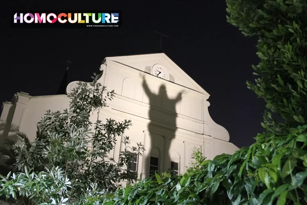A ghostly figure illuminated on the back of a church in the French Quarter in New Orleans. 