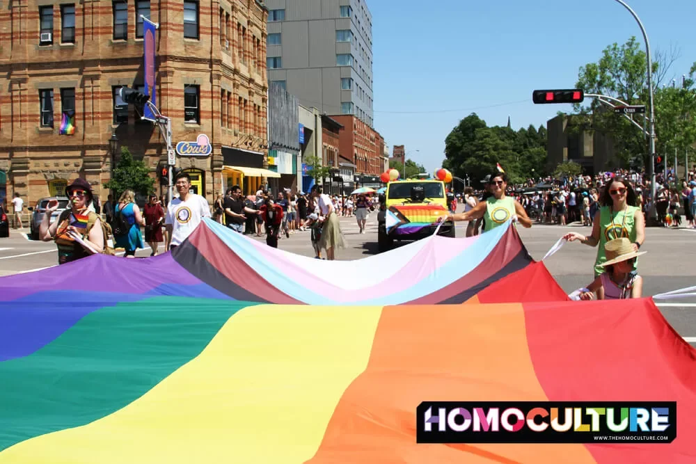 A group carrying a giant Progressive Pride flag in the 2022 Pride PEI parade. 