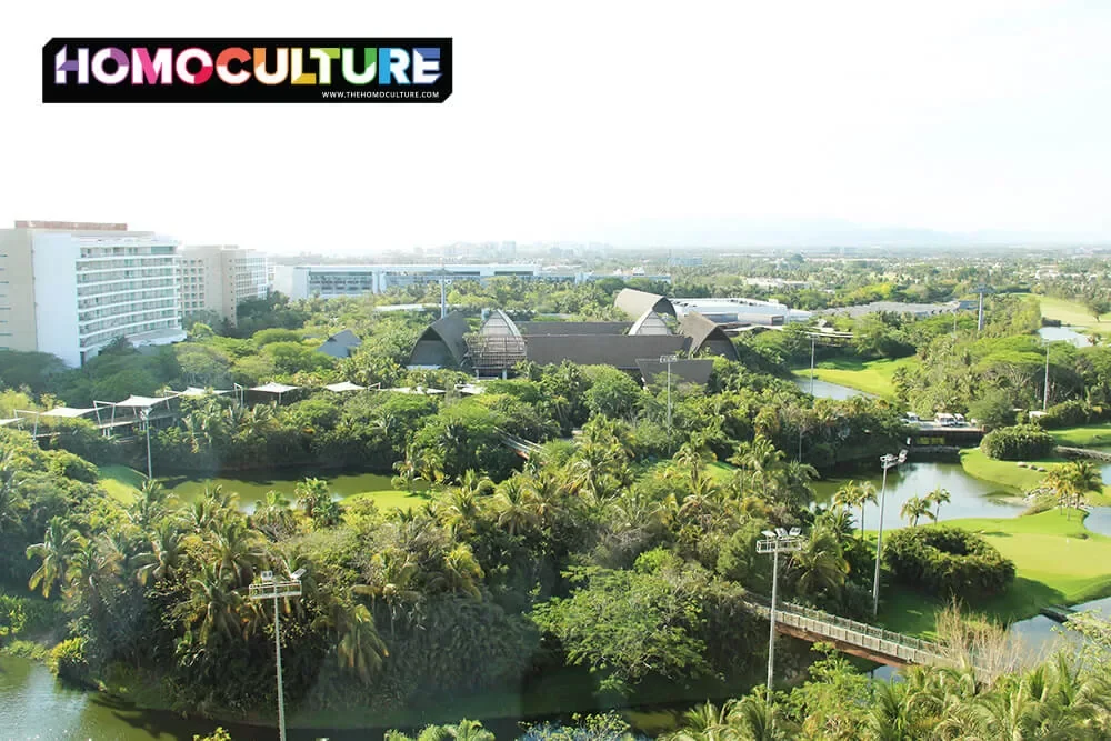 A picturesque view of Vidanta Resort grounds with palm trees, ponds, and and a golf course. 
