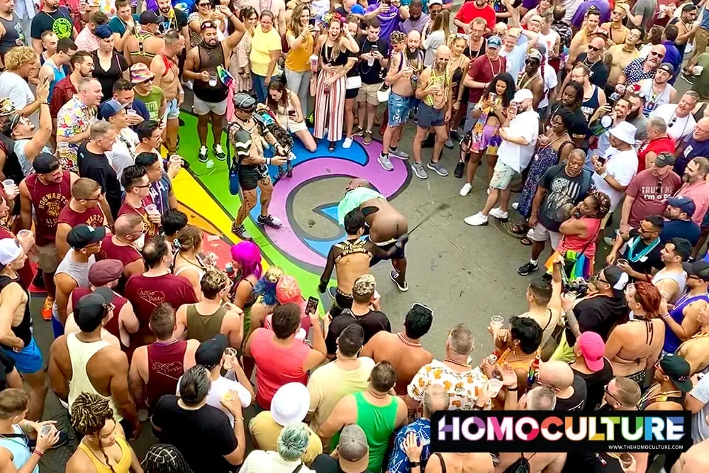 A man being smacked on the ass with a leather riding crop at Southern Decadence 2022. 