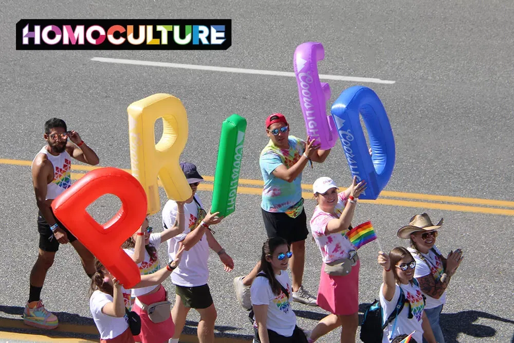 A group of people holding a rainbow PRIDE sign in the 2023 Denver Pride Parade. 