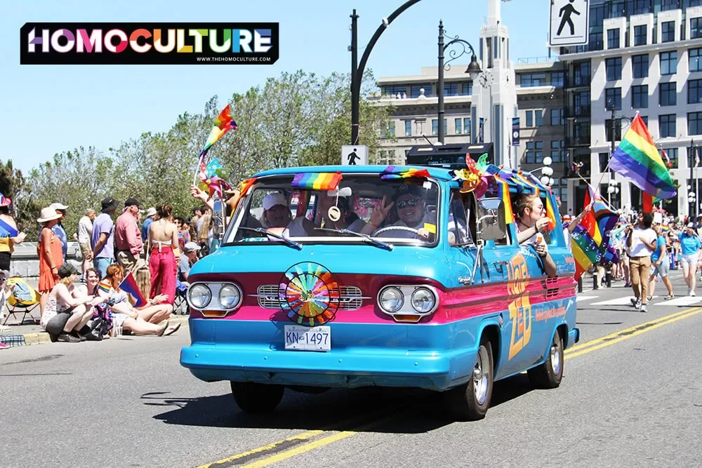 The Hotel Zed retro van decorated with Pride flags in the 2022 Victoria Pride parade.