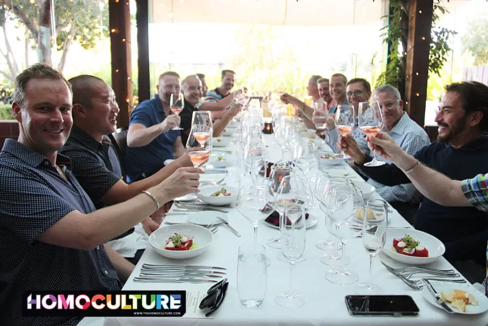 A group of friends toasting at a winemarkers dinner during Gay Wine Weekend 2023.