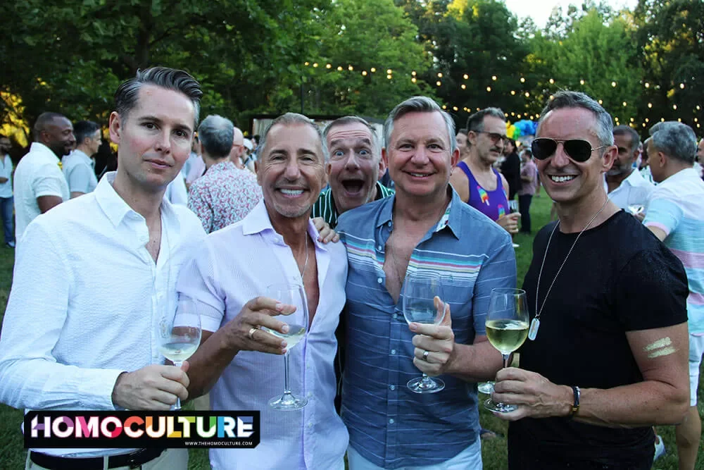 A group of friends cheers during the Twilight T-Dance at Gay Wine Weekend 2023. 