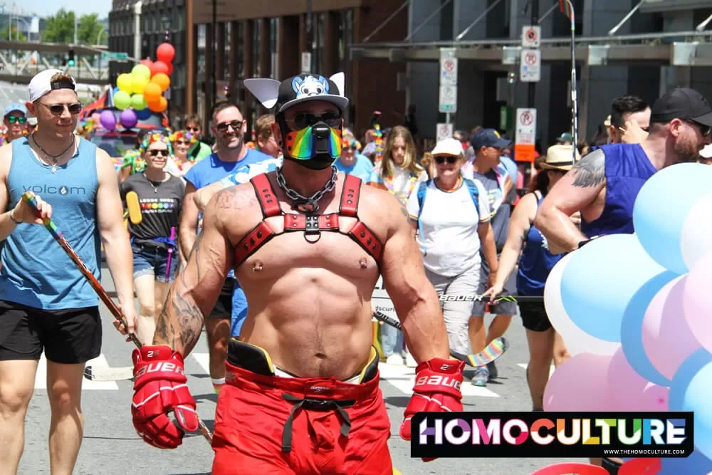 A muscular man wearing a red harness and dog mask at the 2022 Halifax Pride parade. 