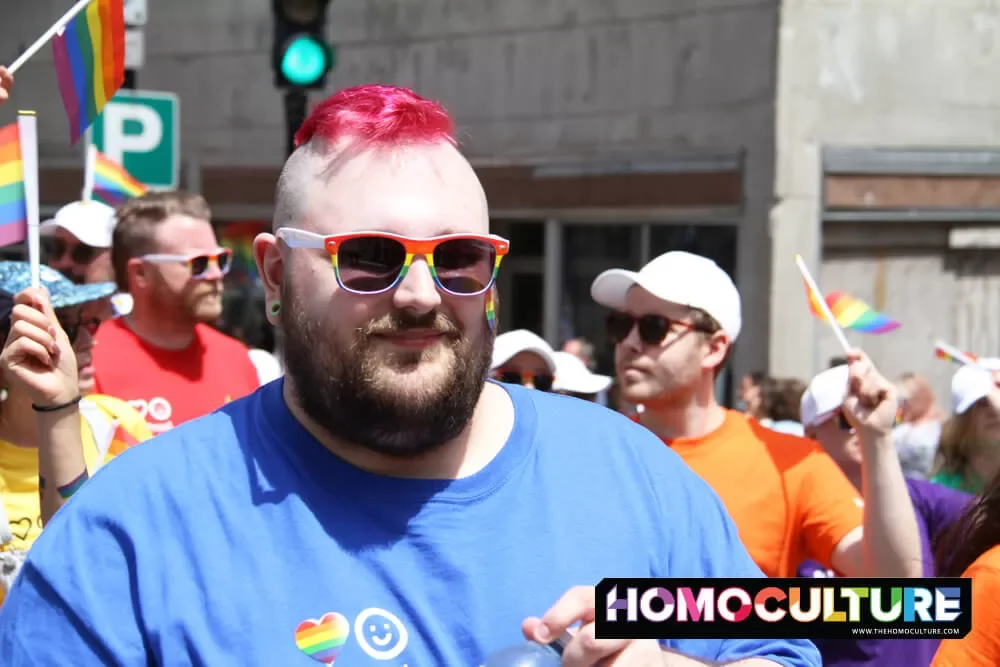 A man with pink hair, wearing rainbow sunglasses, at the 2022 Halifax Pride parade. 