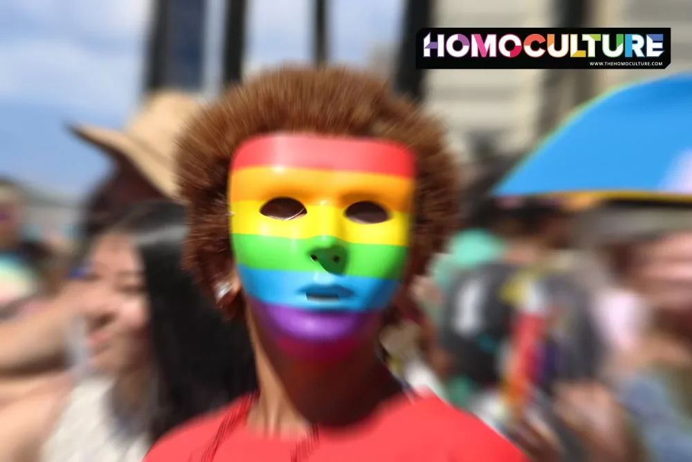 A person wearing a rainbow mask to hide their identity.