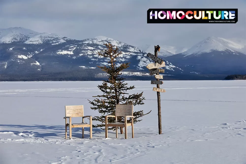 Welcome to the Yukon: A chair and a direction sign with a snow-covered mountain in the background.