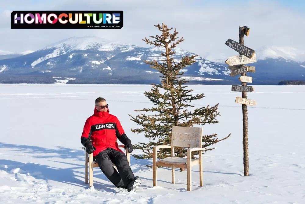 A man on vacation, sitting on a frozen lake during a sunny day in the Yukon. 
