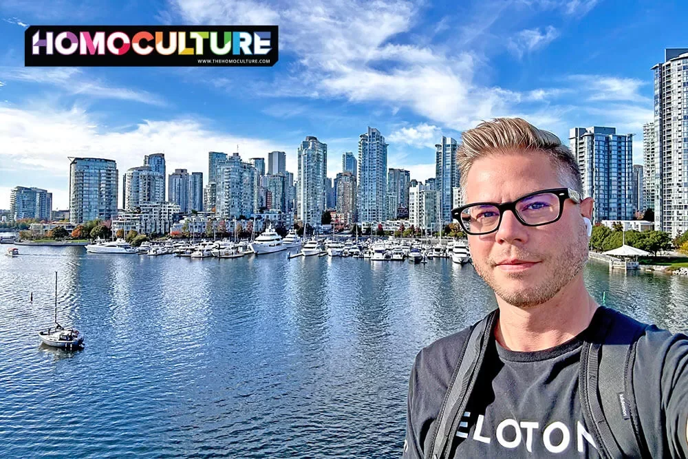 A man wearing glases with the city of Vancouver in the background.