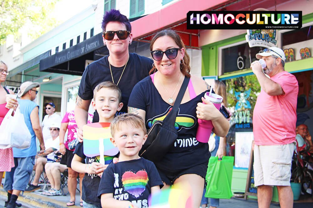 Two lesbian moms with their kids at a Pride parade.
