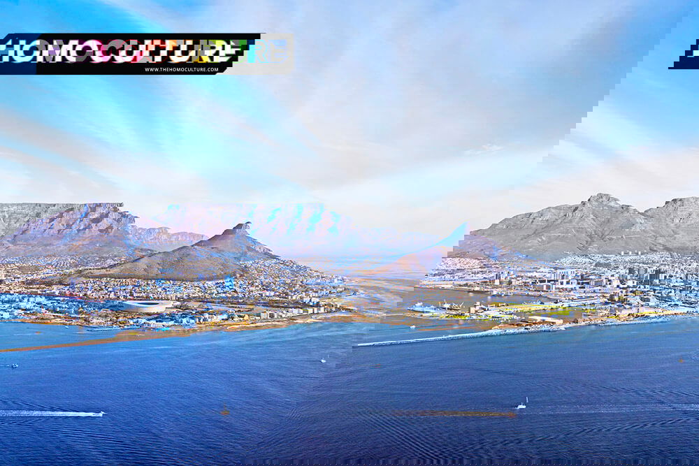 Aerial view of Cape Town, South Africa, featuring Table Mountain, Lion’s Head, the city skyline, and the Atlantic Ocean on a clear blue day.
